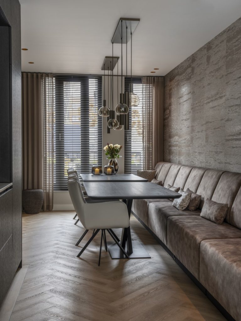 een eetkamer met velvet eetkamerstoelen en eetkamerbank
